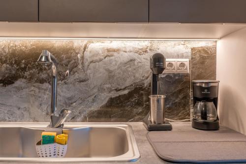 a kitchen counter with a sink and a coffee maker at Artemida Beach Apartment 2 in Artemida