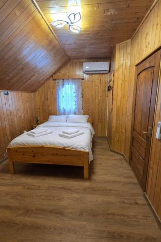 a bedroom with a bed in a wooden room at Casa delta verde in Mahmudia