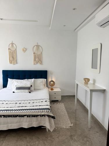 a bedroom with a blue and white bed and a desk at L'œil de Fatma in Tunis