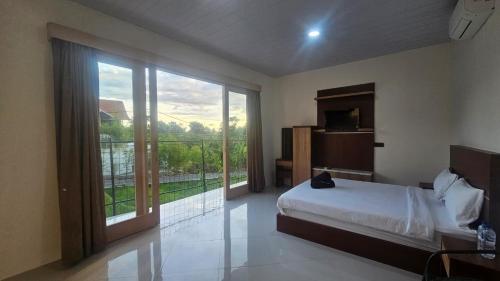 a bedroom with a bed and a large window at Bahtera Canggu in Dalung