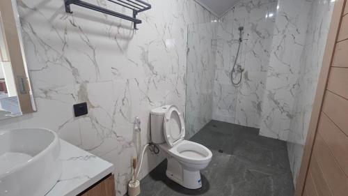 a white bathroom with a toilet and a sink at Bahtera Canggu in Dalung