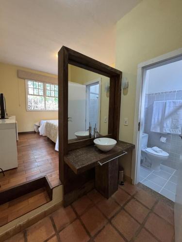 a bathroom with a sink and a mirror and a shower at Pousada Vila Leopoldina in Tiradentes