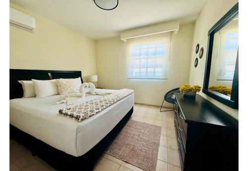 a bedroom with a large white bed and a window at SM Apartments in San José del Cabo