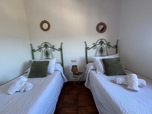 two twin beds in a room with white sheets at Casita El Granero in Iznatoraf