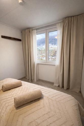 a bedroom with a large bed with a large window at Juralodgespa Chalet Emma in Courrendlin