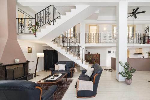a living room with couches and a staircase at Katerina's Sunset Apartment in Episkopianá