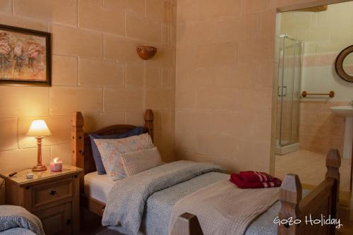 a bedroom with two beds and a shower at Ta Guzeppi Xaghra in Xagħra