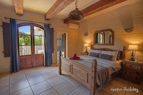 a bedroom with a bed and a large window at Ta Guzeppi Xaghra in Xagħra