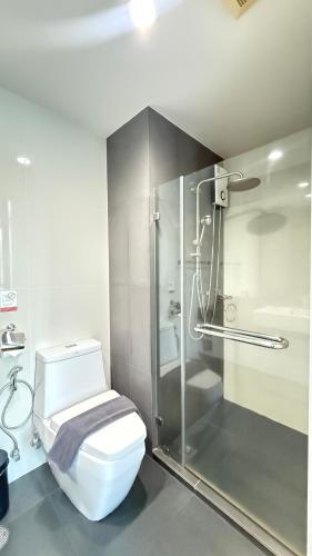 a bathroom with a toilet and a glass shower at 6th Avenue Surin by Win217 in Surin Beach
