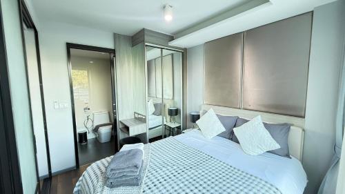a bedroom with a bed and a bathroom with a sink at 6th Avenue Surin by Win217 in Surin Beach