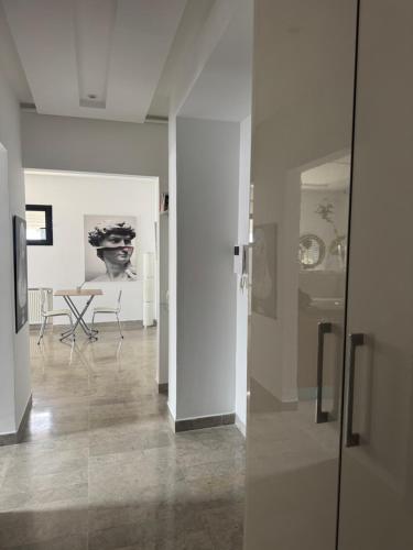 a room with white walls and a table and chairs at Le David in Tunis
