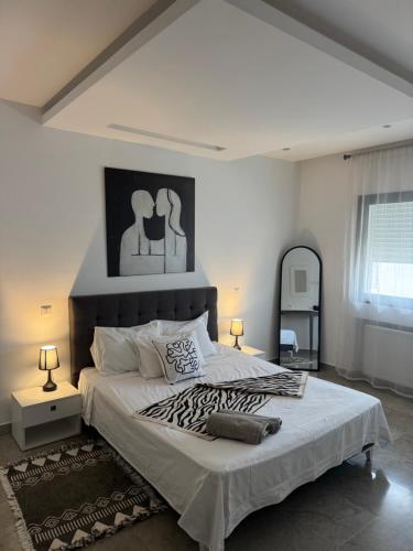 a bedroom with a large bed and a mirror at Le David in Tunis