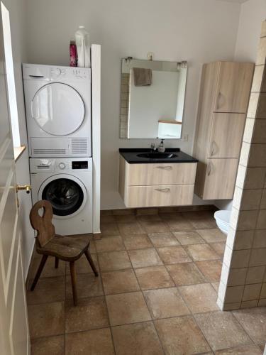 a small bathroom with a washing machine and a chair at Mosborg Gæstehus in Ulfborg