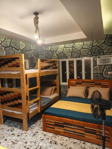 a bedroom with two bunk beds and a fan at Ocean View and Beach Access Rustic Stone House in Bolinao