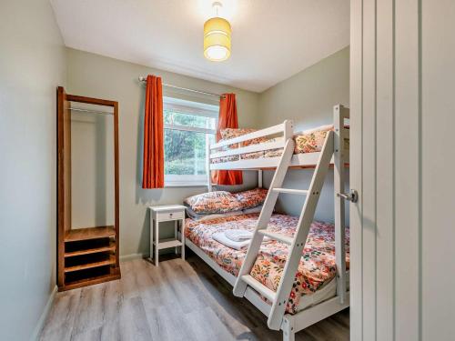 a bedroom with two bunk beds and a mirror at 2 Bed in Swansea oc-90367 in Oxwich
