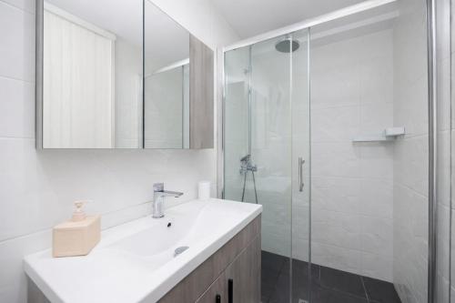 a white bathroom with a sink and a shower at Villa Leo in Barbati