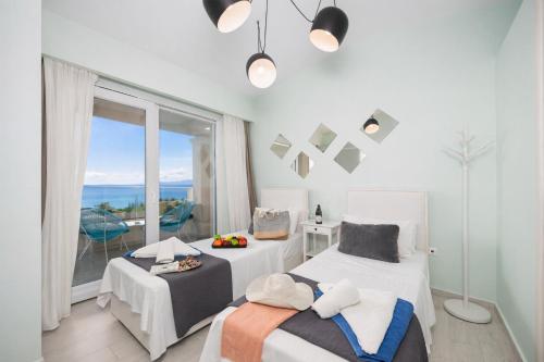 a bedroom with two beds and a large window at Villa Leo in Barbati