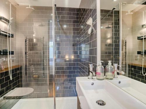 a bathroom with a sink and a glass shower at 4 Bed in Llandysul oc-93546 in Henllan