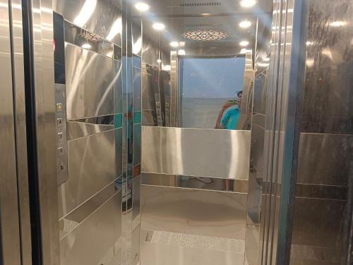 a glass shower in a bathroom with a mirror at Hotel Harihar Atithi Bhawan in Naimishāranya