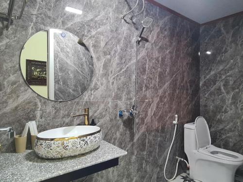 a bathroom with a sink and a toilet and a mirror at Snow Homestay in Ninh Binh