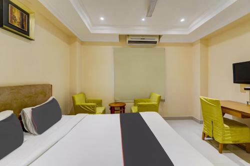 a room with a bed and chairs and a table at Open Hotel by Olive - Ashok Nagar in Chennai