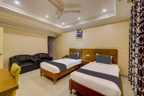 a hotel room with two beds and a couch at Open Hotel by Olive - Ashok Nagar in Chennai