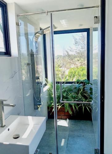 a bathroom with a glass shower and a sink at Pini Villa in Ampara