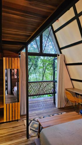 a room with a bed and a table on a balcony at RESERVA BOWARA - Ecolodge in Pamplonita