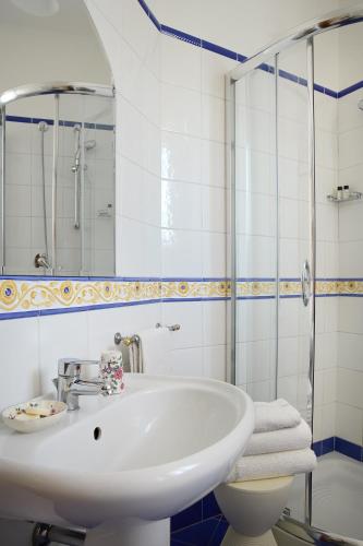 a white bathroom with a sink and a shower at Albergo Villa Cristina in Spoleto