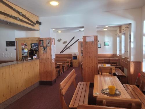 a restaurant with wooden tables and wooden benches at Horská bouda Aldrov in Vítkovice
