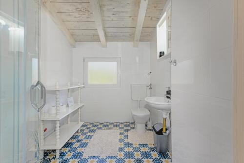 a white bathroom with a toilet and a sink at Casablanca-Brgulje in Brgulje