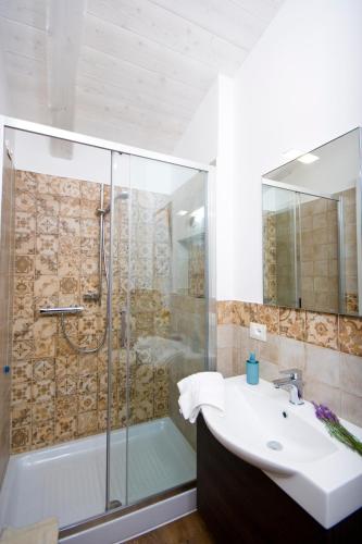 a bathroom with a sink and a glass shower at Bellafiora Affittacamere in Osimo