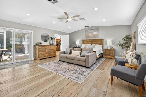 a bedroom with a bed and a couch and chairs at Steps to beachTiki BarHeated Poolfun! in Clearwater Beach