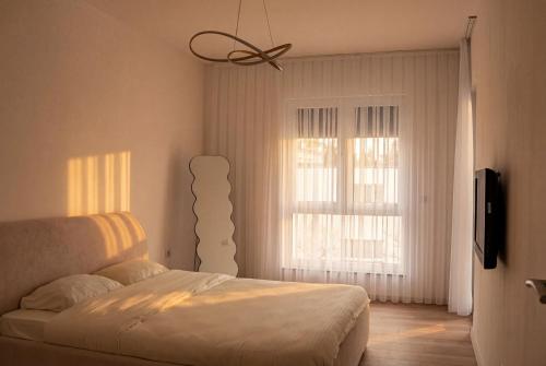 a bedroom with a bed and a window at Inviti Apartments in Gjakove