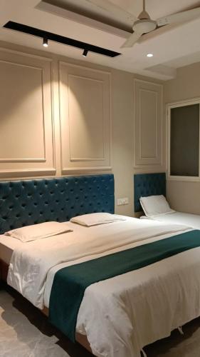 a bedroom with a large bed with a blue headboard at Hotel Classio Ali Asgar in Jaorā