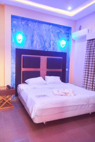 a bedroom with a large bed with a large headboard at Boripe Hotel And Suites, Oluponna, Osun State in Olupona