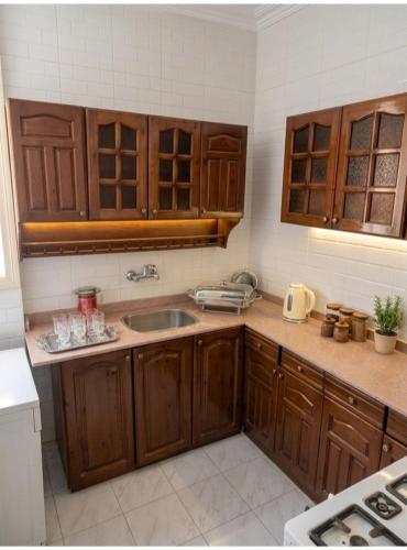 a kitchen with wooden cabinets and a sink at HK Pyramids Guest House Hospitality& Kindness in Cairo