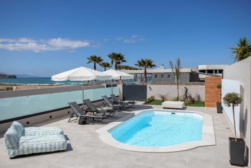 a swimming pool on a patio next to the beach at AZURE Seaside Residence in Kokkini Khanion