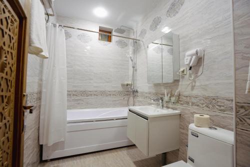 a bathroom with a tub and a toilet and a sink at SHakhina premium hotel in old city in Bukhara
