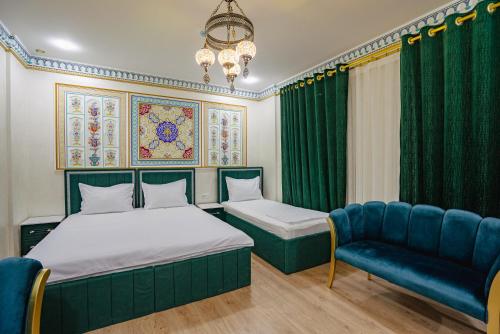 a bedroom with a bed and a couch and a chandelier at SHakhina premium hotel in old city in Bukhara