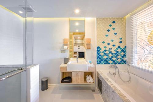a bathroom with a sink and a shower at LIV Hotel Phuket Patong Beachfront in Patong Beach