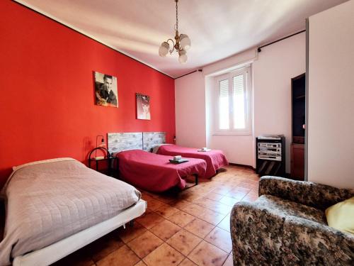 a bedroom with red walls and two beds and a couch at Camera con Vista B&B in Ancona