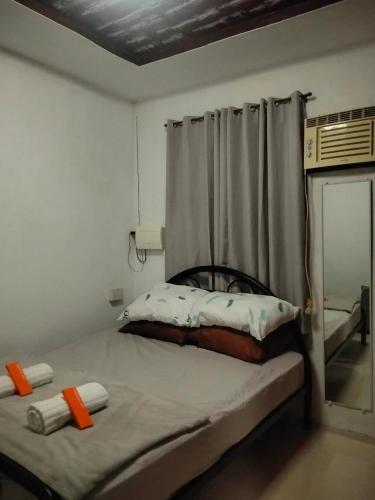 a small bedroom with a bed with a curtain at Digong Guest House Mulogan in Molugan