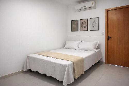 a small bedroom with a bed with white sheets at Flats Temáticos - By Temporada Expert - Conforto e Climatizado in Feira de Santana