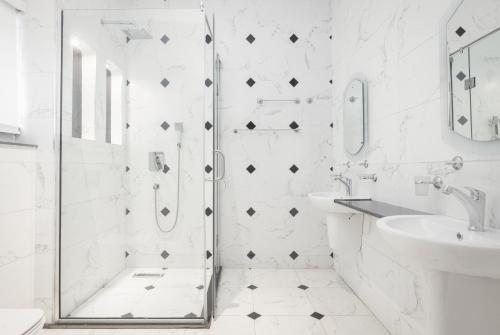 a white bathroom with a shower and a sink at D'Crown Place in Abuja