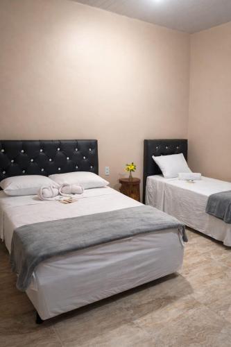 a bedroom with two beds with white sheets at Hotel Star Rio in Novo Airão