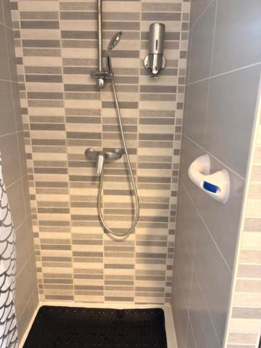 a shower with a hose in a bathroom at Maison entière avec jardin , Proche Bordeaux, Rocade et Arkéa Arena in Bouliac