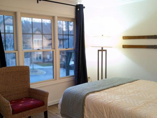 a bedroom with a bed and a chair and a window at Premium 3 Bed Top Floor Views in Vernon Township
