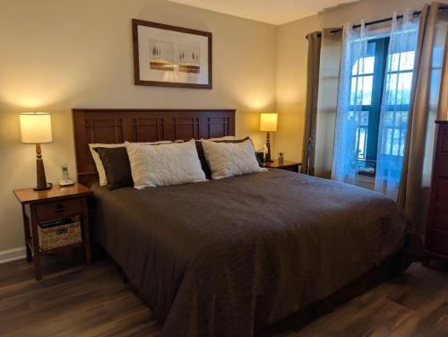 a bedroom with a large bed with two lamps on tables at Country Charm 1 Bd Balcony Views in Vernon Township