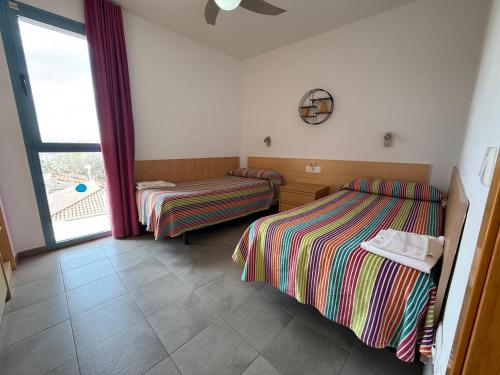 a room with two beds and a window at Rentalmar Costa Verde in Cambrils